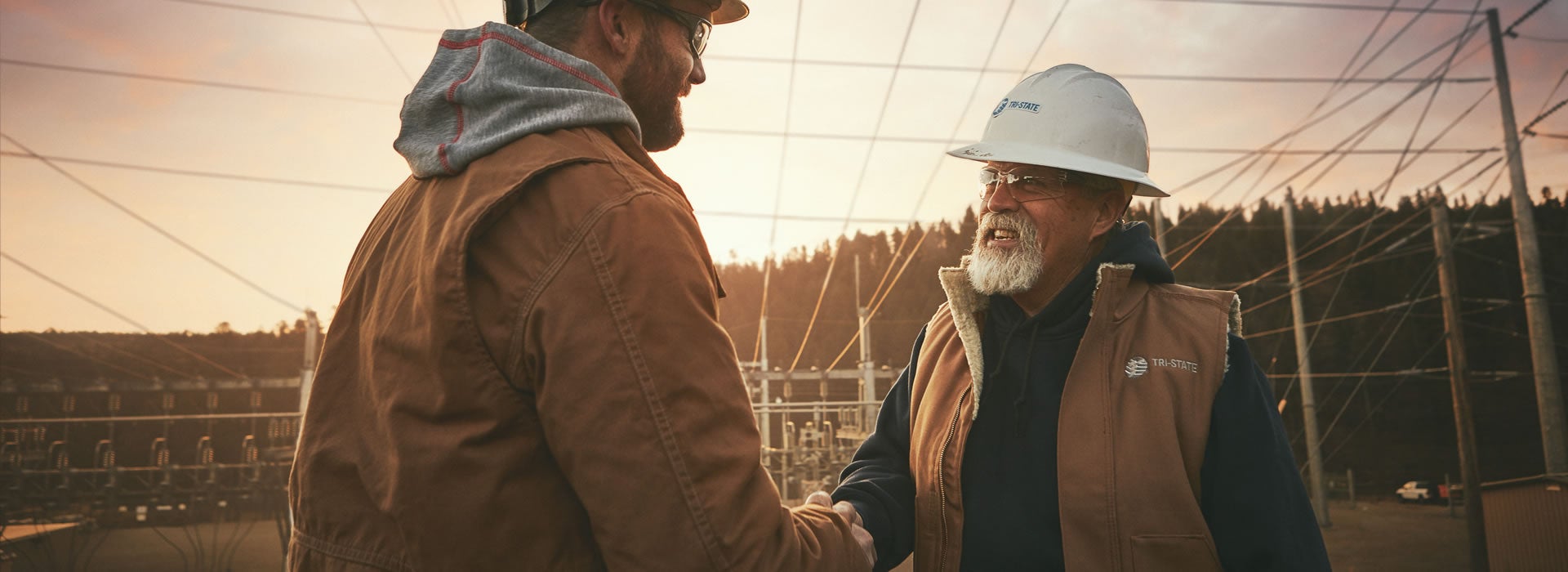 Men at a substation shaking hands