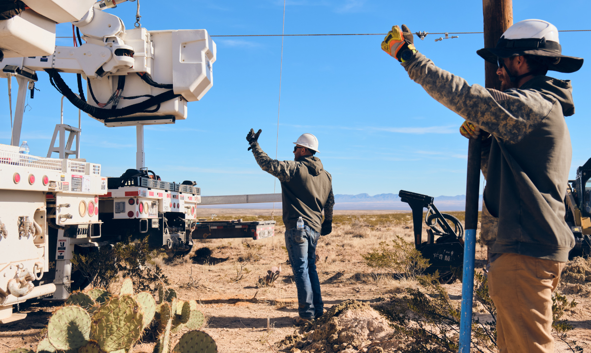 Two team members helping direct crane