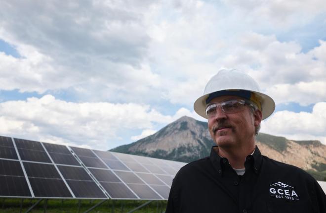Matt Feier looking optimistic in front of solar panels