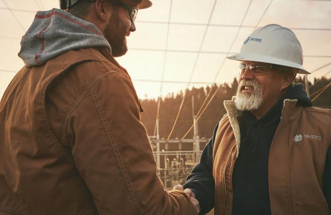 Men at a substation shaking hands