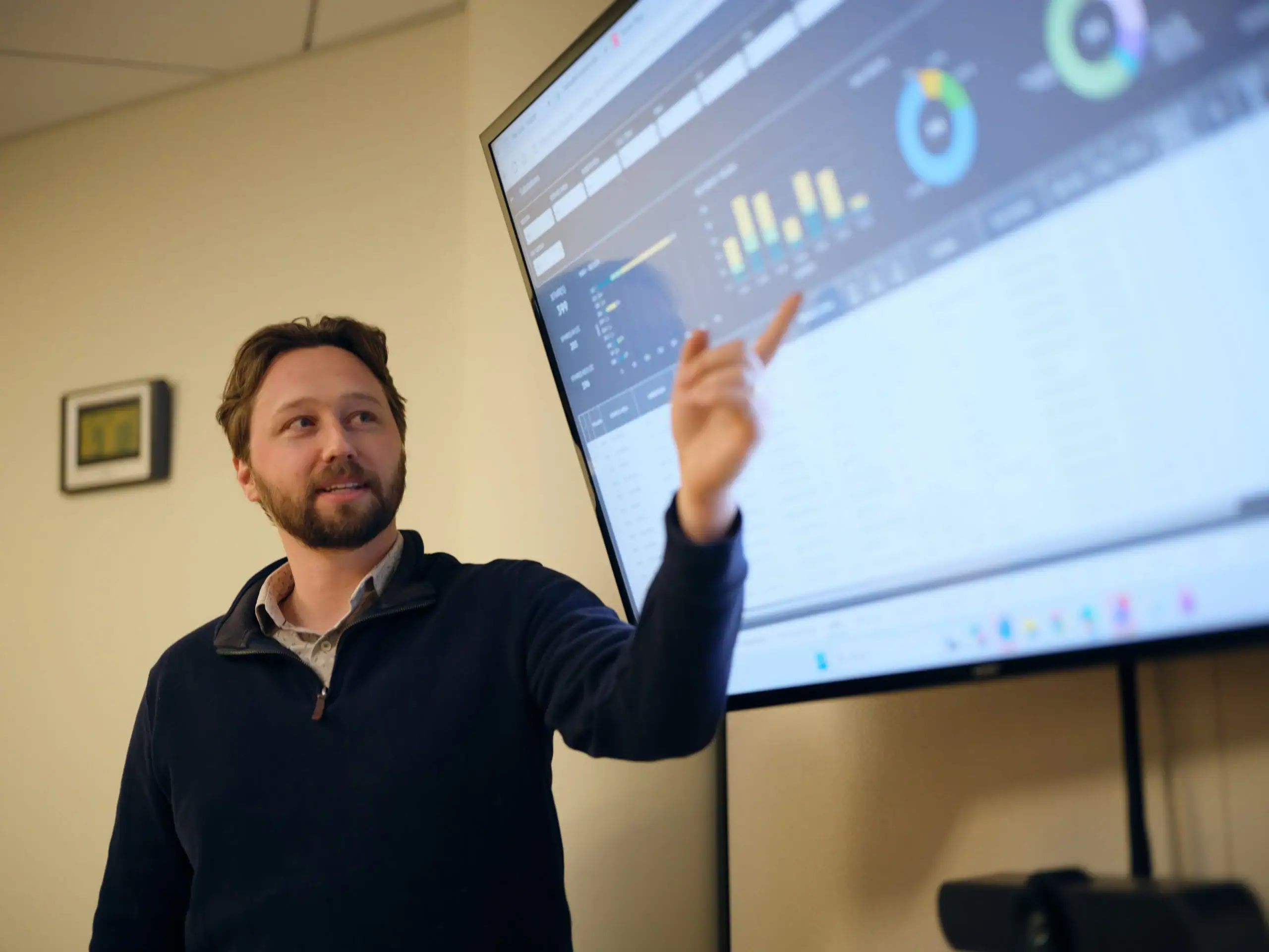 man pointing at screen with numbers