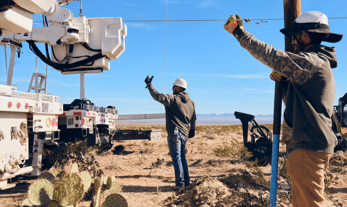 Two team members helping direct crane